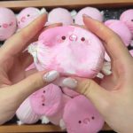 Pink pig candy-shaped squishy held in two hands